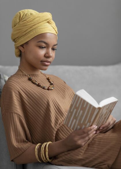 头巾放松的阿拉伯女人在家看书妇女文学阿拉伯妇女