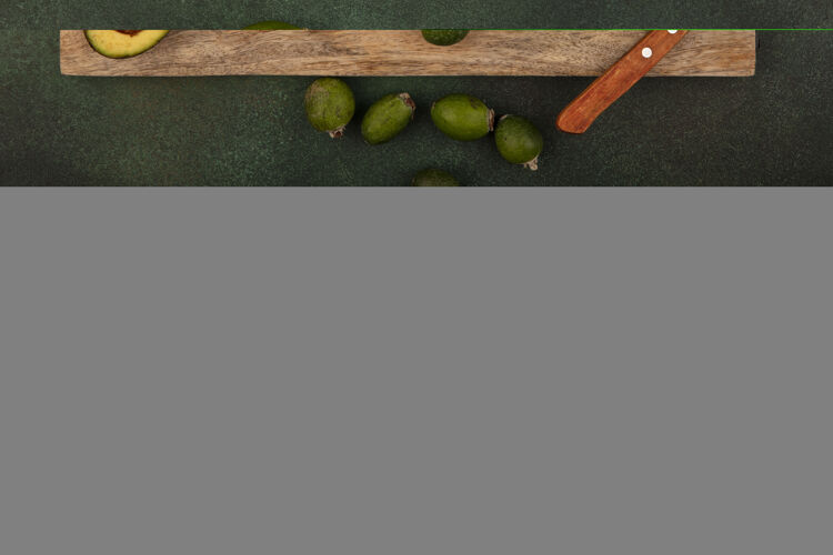 鳄梨俯瞰美味的鳄梨与切片的木制厨房板与黄瓜片与酸橙和肥肉隔离在一个绿色的表面肥肉膳食酸橙