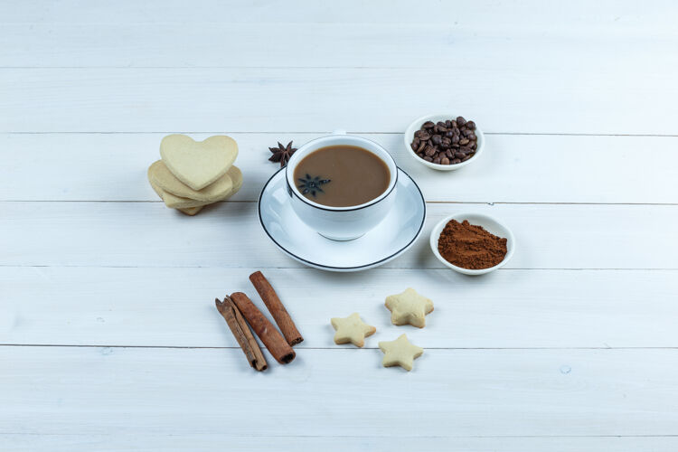 质地一套饼干 香料 咖啡豆 磨碎的咖啡和咖啡在一个木制背景上的杯子高角度视图豆子自然