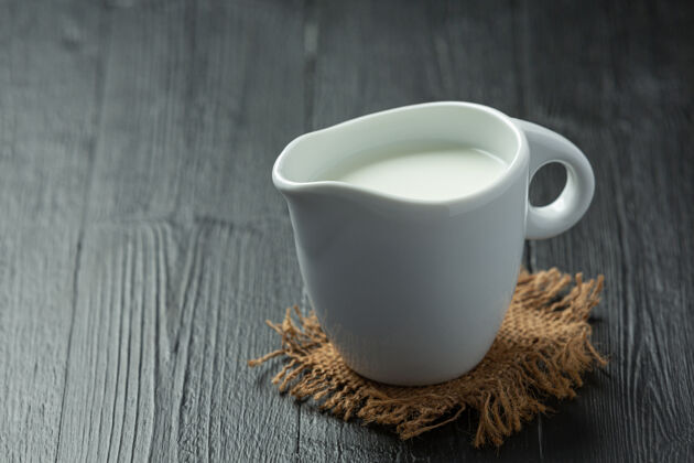 食物一杯牛奶放在深色的木头表面单人钙奶制品