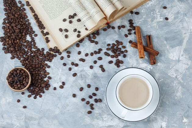 肉桂咖啡在一个杯子里 咖啡豆 书 肉桂棒顶视图在灰色灰泥背景上味道大笑咖啡馆
