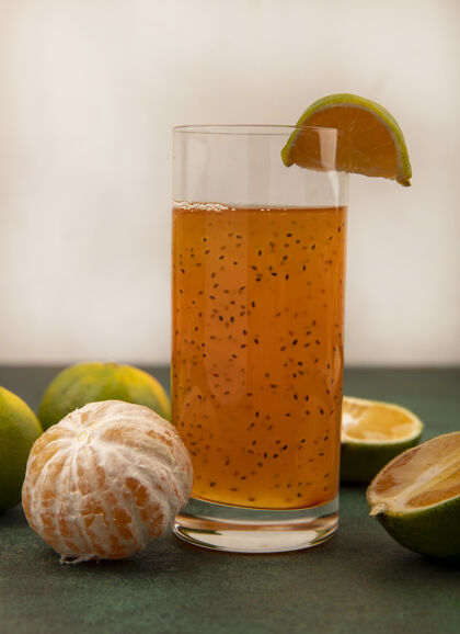 视野侧视图健康和新鲜的橘子与新鲜果汁在一个白色的墙上玻璃橘子果汁橙子