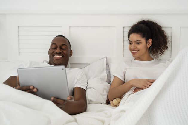 儿子快乐的年轻夫妇在平板电脑上看东西爸爸家庭笔记本电脑