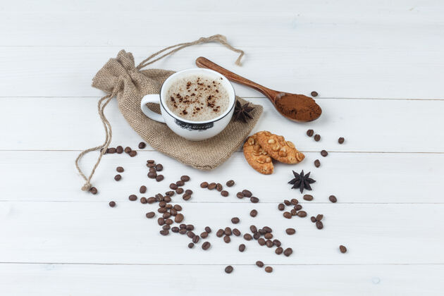 研磨一套磨碎的咖啡 香料 咖啡豆 饼干和咖啡在一个木袋背景上的杯子高角度视图角热的咖啡馆