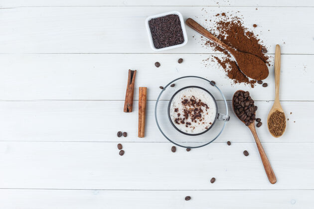 粗麻布一套磨碎的咖啡 咖啡豆 肉桂棒和咖啡在一个木杯背景上顶视图咖啡馆咖啡烤