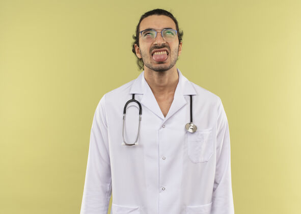 医生年轻的男医生戴着眼镜 穿着白袍 听诊器露出舌头向上绿色舌头