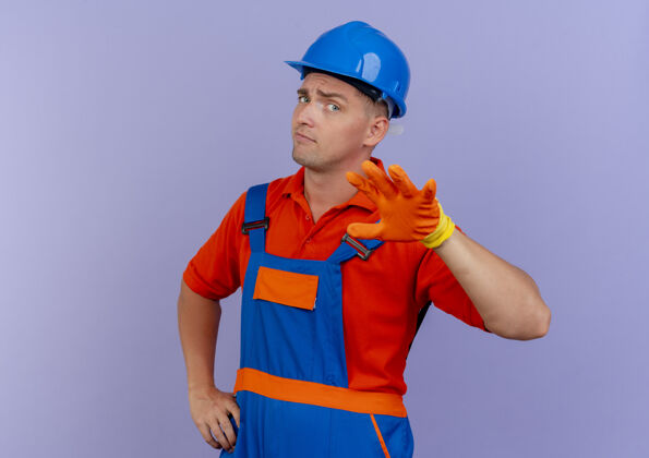 紫色年轻的男建筑工人穿着制服 戴着安全帽 戴着手套伸出手建筑工人手套年轻人