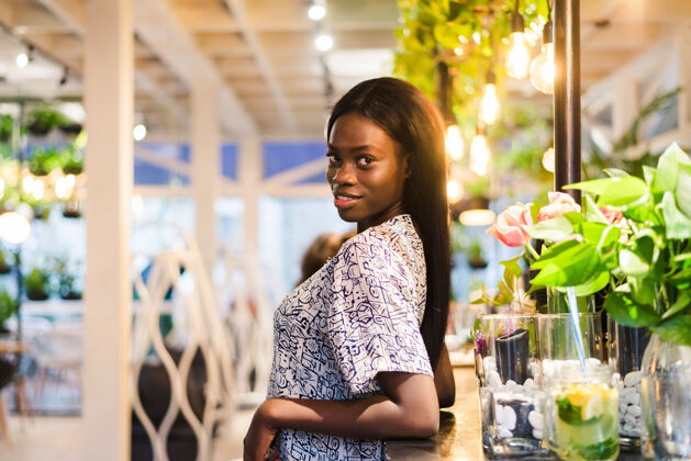 冰沙年轻的非洲女人站在咖啡馆里的画像酒吧卷发候选人