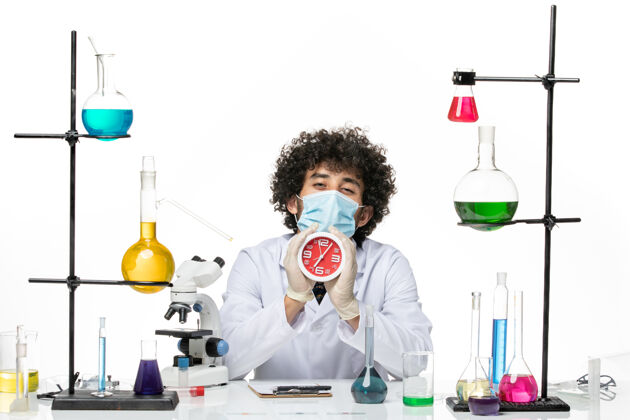 男性化学家正面图：男化学家 穿着医疗服 戴着面具 在空白处拿着时钟医学病毒科学