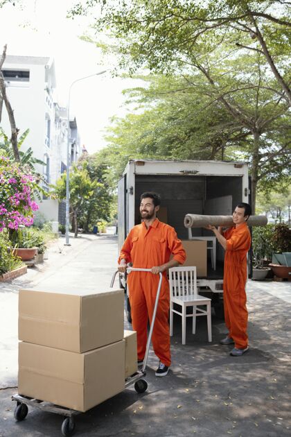 送货员年轻送货员从车里搬出东西的垂直镜头男人快乐邮件