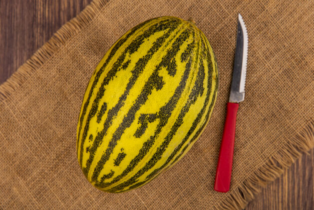 营养顶视图新鲜的哈密瓜在布袋上用刀在木制表面甜瓜配料火腿