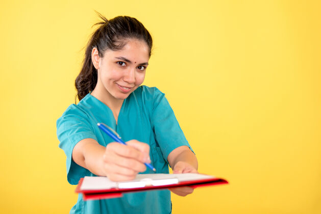正面前视图微笑的年轻女性拿着剪贴板和黄色背景上的笔男性人物钢笔