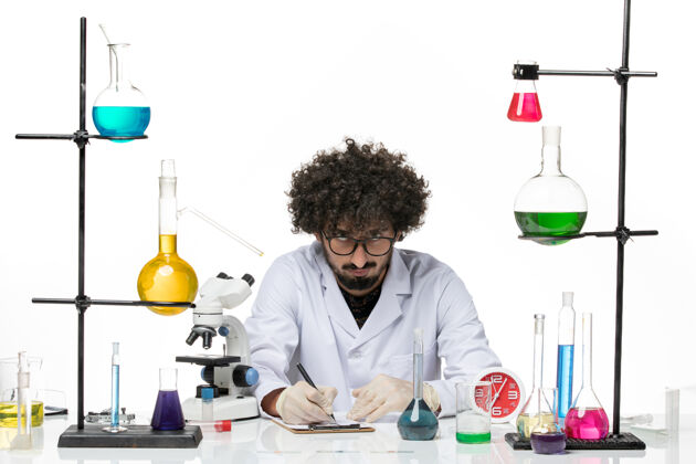 医学正面图穿着医疗服的男性化学家在空白处写下笔记羽绒实验室医生