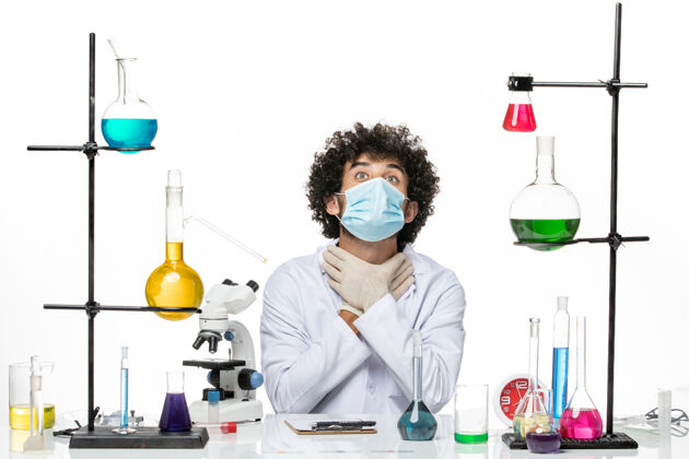 男性化学家正面图：男化学家穿着医疗服 戴着面具 把自己塞进了空白处实验室他自己外套