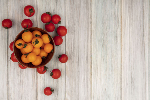 美味健康的橙色西红柿的顶视图在一个木制碗上 红色西红柿被隔离在一个灰色的木制表面上 有复制空间西红柿饮食美味