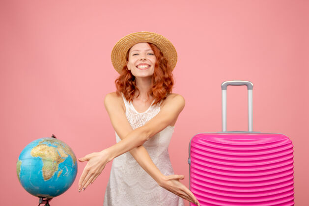 模特年轻女性游客的正面图 粉红色的墙上挂着粉红色的包旅行衣服衣服