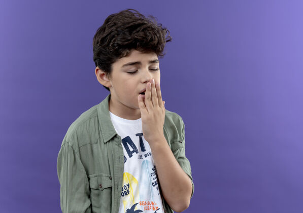 掩护闭着眼睛打呵欠的小男生捂着嘴用手隔离在紫色的墙上留着复印空间闭上小男孩手