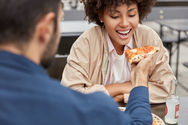 健康可爱的情侣在户外自助餐厅吃披萨快速非洲享受
