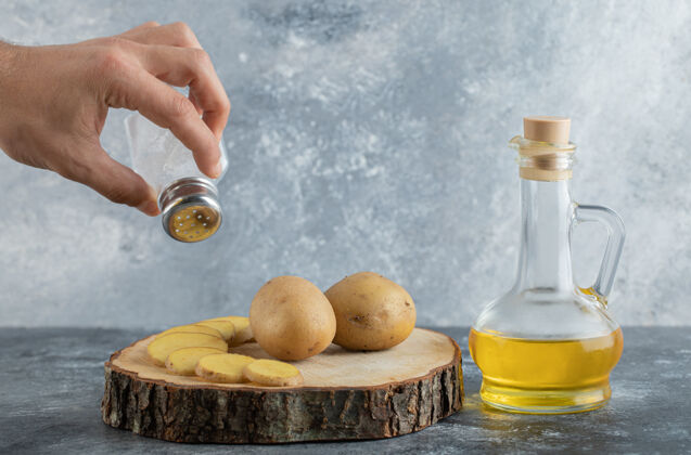 饮食把盐倒在土豆片上的人食物橄榄油