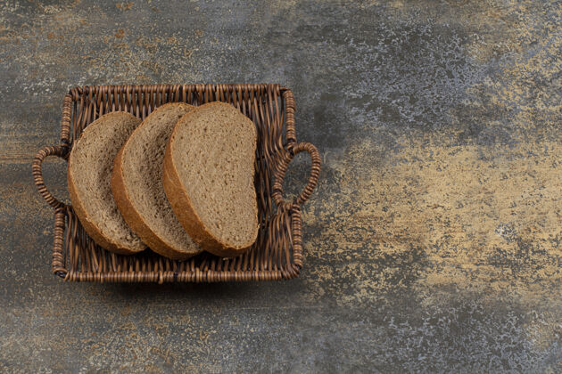 吐司木篮里的黑麦面包片有机自然新鲜