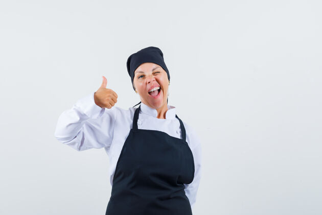 制服身着制服的女厨师 围裙上露出大拇指 看上去很开心 正前方视图时尚可爱年轻