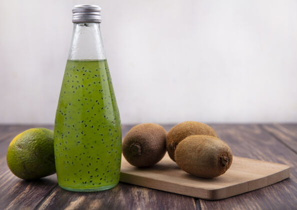 果汁前视图果汁瓶与绿色橘子和猕猴桃在砧板上橘子瓶子猕猴桃