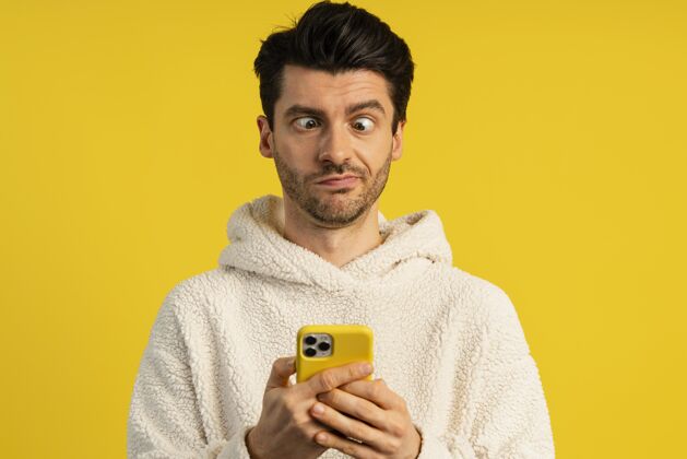 个体男人拿着智能手机做傻脸的前视图水平表情男性