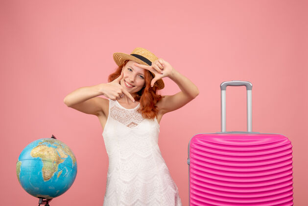 模型年轻女性游客的正面图 粉红色的墙上挂着粉红色的包时尚航行肖像