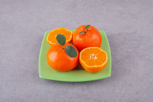 甜点整个橘子和切成片的橘子放在石头上食物切柑橘