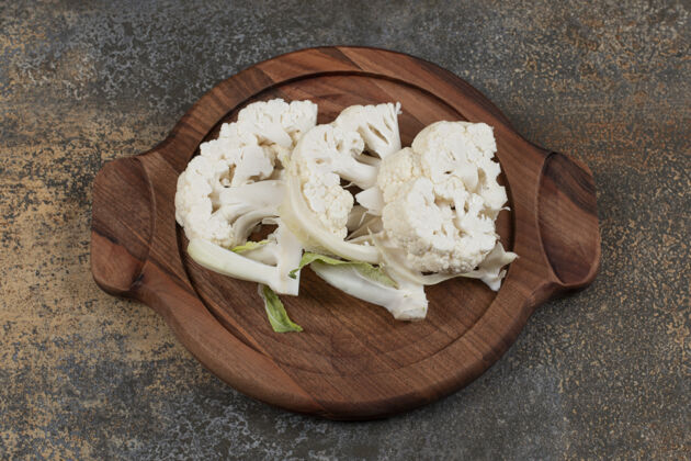 美味把花椰菜片放在木板上 放在大理石表面板菜生的成熟的