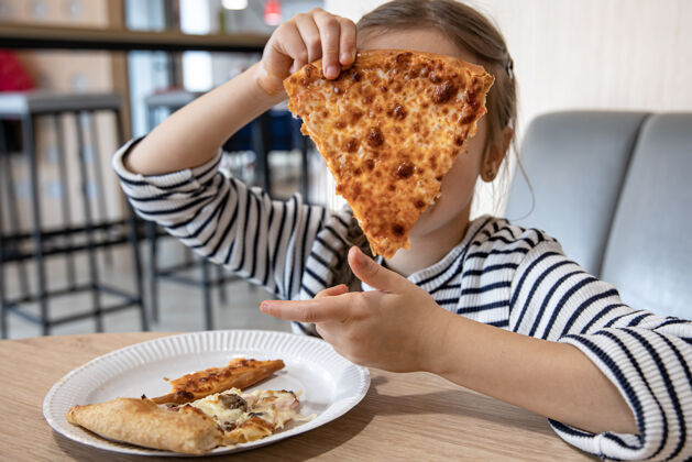 小有趣的小女孩午餐吃奶酪披萨特写比萨饼水平美味
