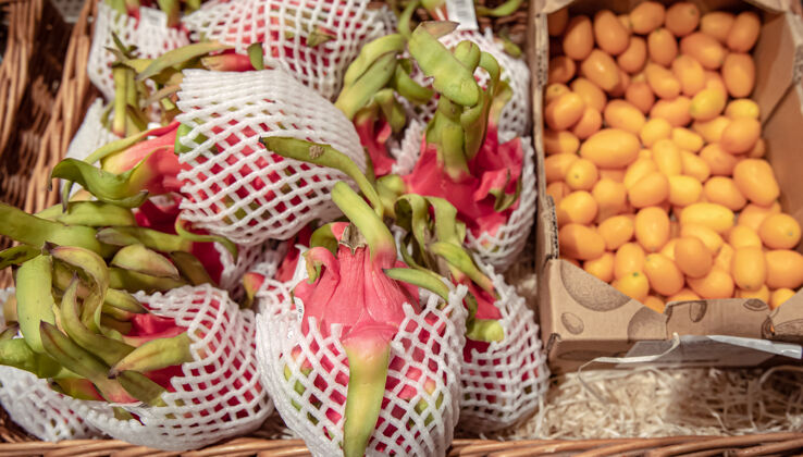市场超市柜台上的火龙果和金盏的特写镜头篮盒子食品