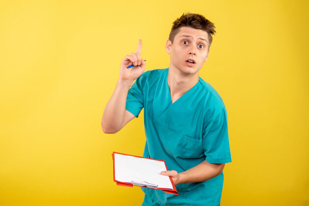 医院正面图：年轻的男医生 穿着黄色背景的医疗服肖像人物医学