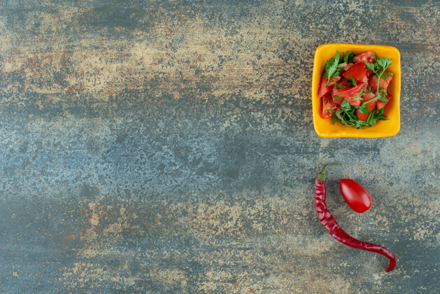 美味黄色盘子里的美味沙拉 大理石背景上有胡椒和西红柿沙拉健康可口