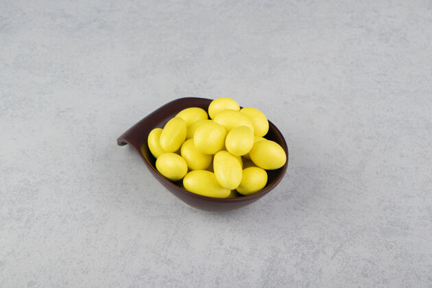 堆黄色的牙龈在碗里的大理石表面耐嚼美味口香糖