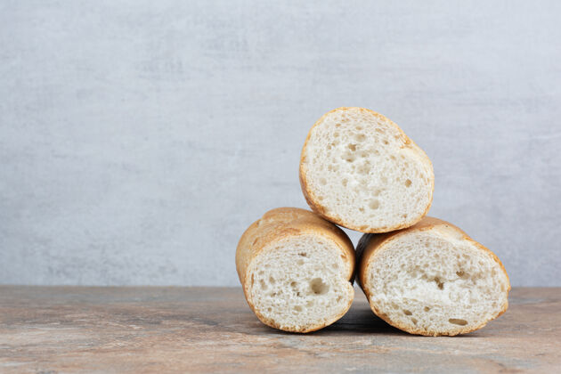 食物大理石背景上的半切面包美味松脆半块