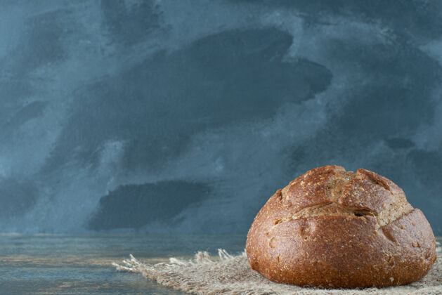 食品一个全新的棕色面包放在麻布上糕点面包美味