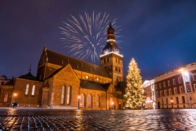 人行道在一个繁星点点的夜晚 教堂里五颜六色的烟花的低角度拍摄圣诞节建筑物灯光