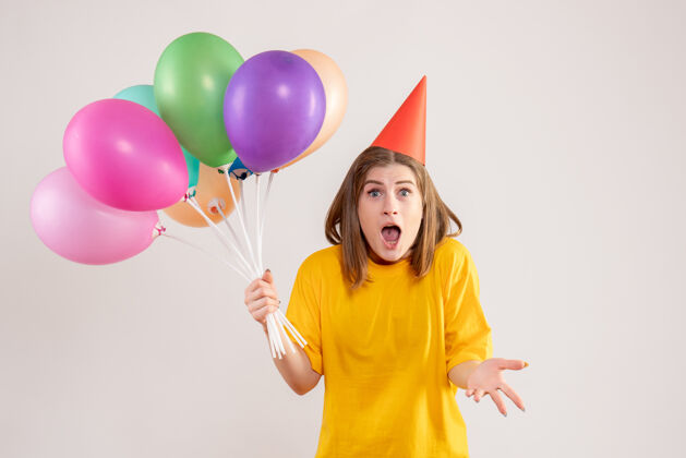 庆祝手持白色气球的年轻女子年轻女性情感吹