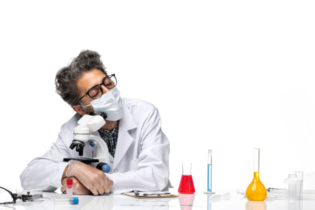 技术员正面图穿着白色医疗服的中年科学家坐在显微镜下睡觉研究桌子人