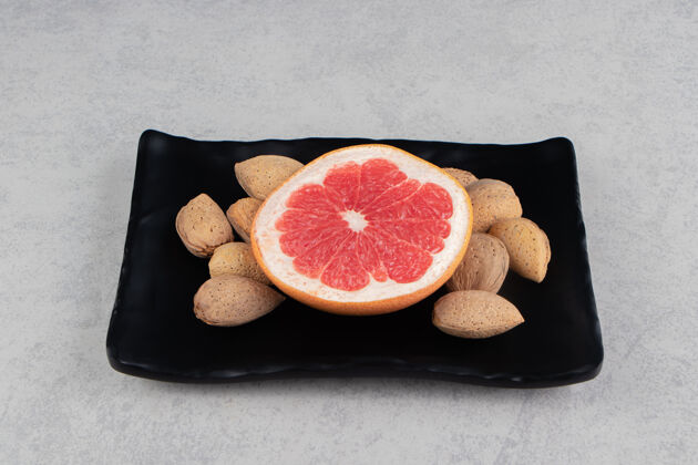 美味葡萄柚和杏仁在木板上 在大理石表面董事会美味有机
