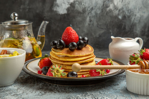 覆盆子正面图：美味的薄饼配水果和茶 清淡的水果早餐甜点早餐奶油