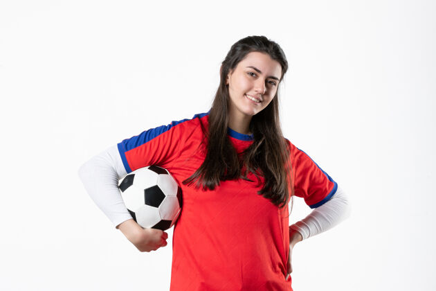 足球前视图穿着运动服的年轻女性 白色墙壁上有足球制服球视图