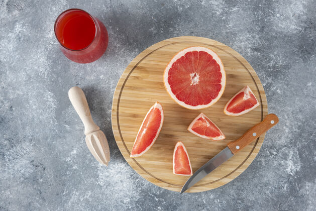 完整一杯新鲜葡萄柚汁 配水果片和木铰刀生动酸食物
