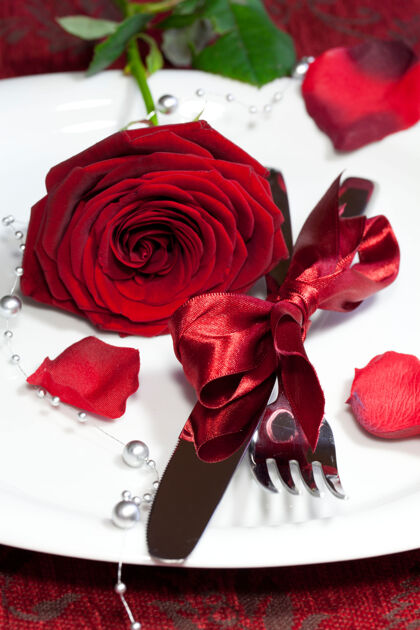 心节日桌上红玫瑰盘子的垂直镜头礼物垂直玫瑰