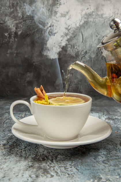 热的观景水壶用茶水倒进茶杯上 茶道上黑漆漆的早晨杯子茶早餐