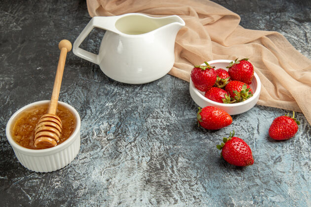 水果正面图新鲜的红色草莓和蜂蜜 表面呈暗红色的水果浆果热的新鲜的红草莓茶碟