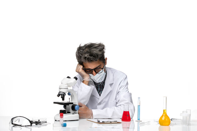 病毒正面图穿着白色医疗服的中年科学家坐着 感觉很累专业实验室化学