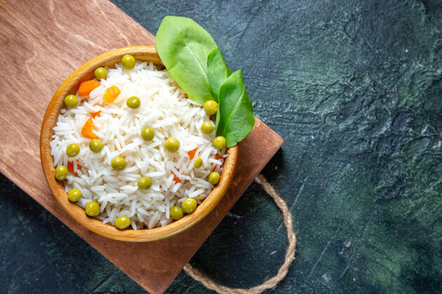 膳食在黑暗的桌子上 盘子里放着美味的绿豆煮米饭顶部健康沙拉