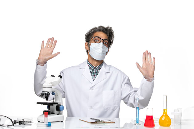 实验正面图身着特殊套装的中年科学家围坐在桌子旁 拿着解决方案科学观点科学